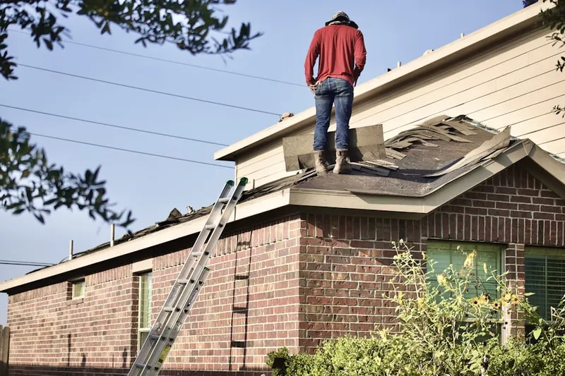 Professional roofer working on a residential roof in Frankfort Center